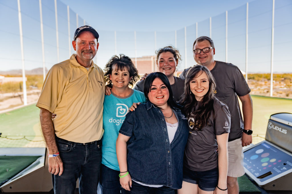 Group of smiling people in front of driving range