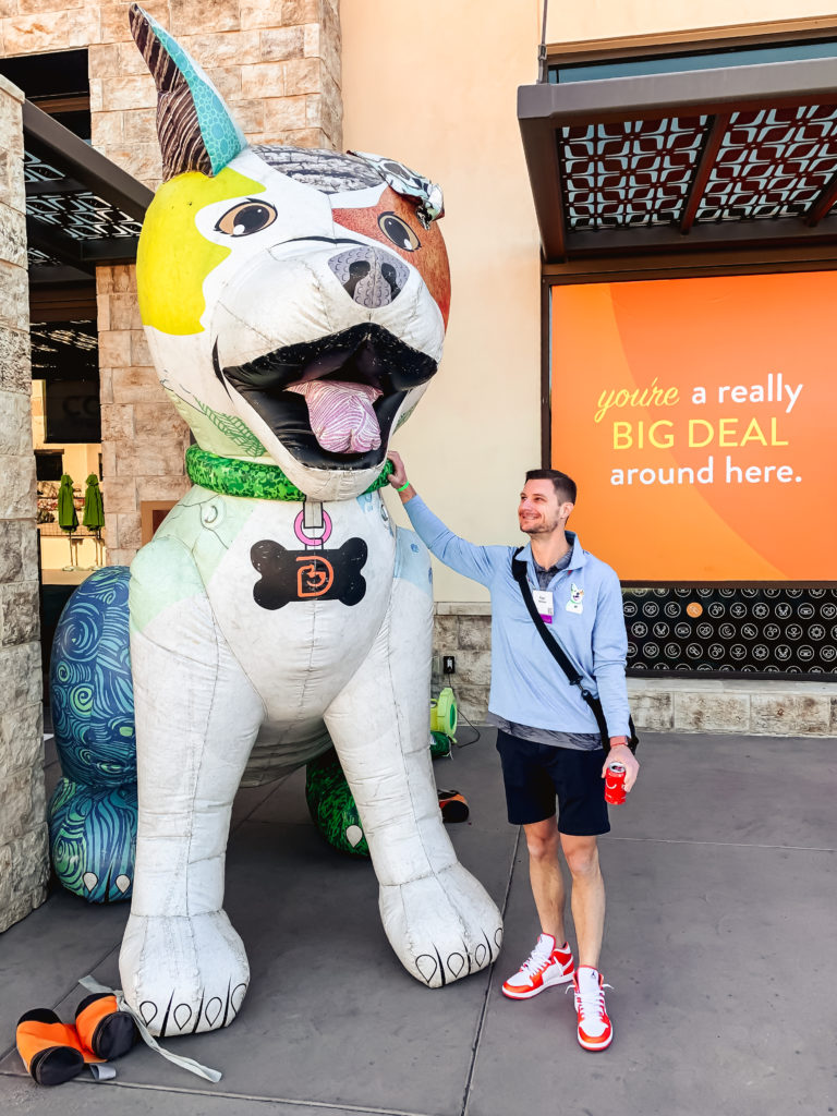 Man standing next to large inflatable Dogtopia dog