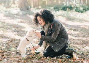 Woman feeding small dog a treat
