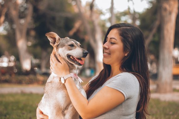 Woman petting a dog outside
