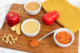 Food board with apple, pumpkin, and other condiments in bowls, with red KONG toy